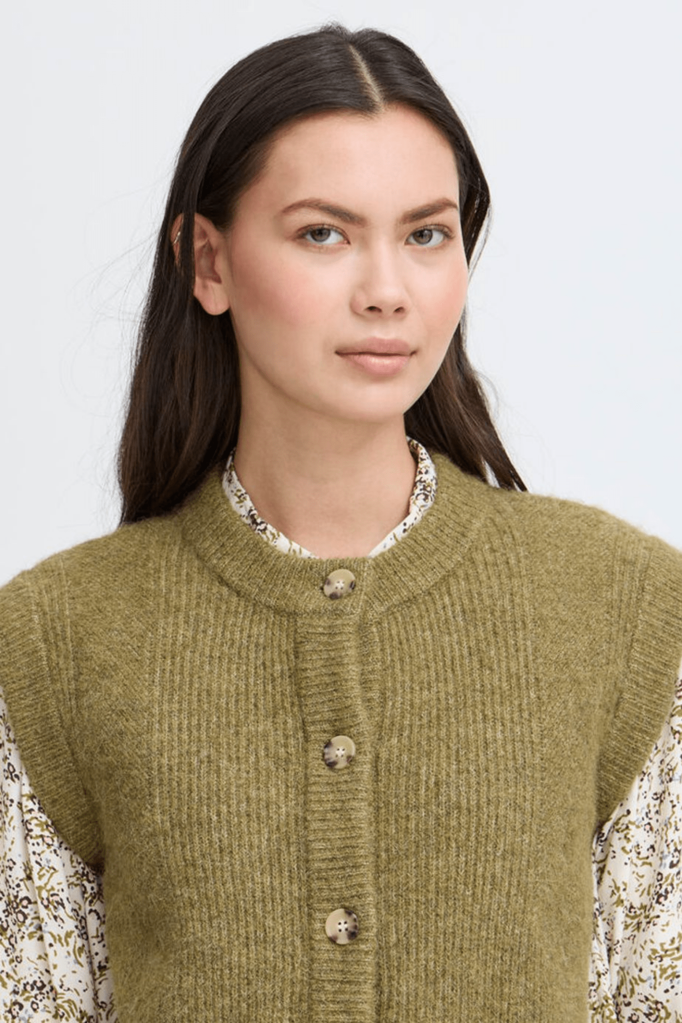 Atelier Rêve Irsilvi Waistcoat, crafted in a cosy moss melange green knit. Available at Dotique Witney