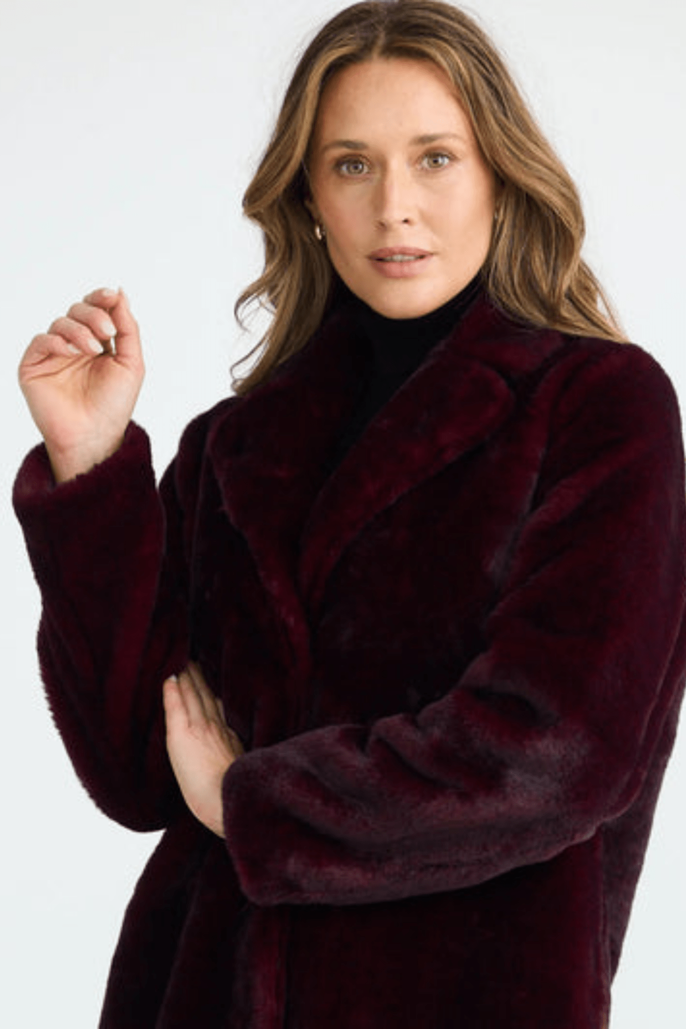Woman wearing a burgundy coat against a white background