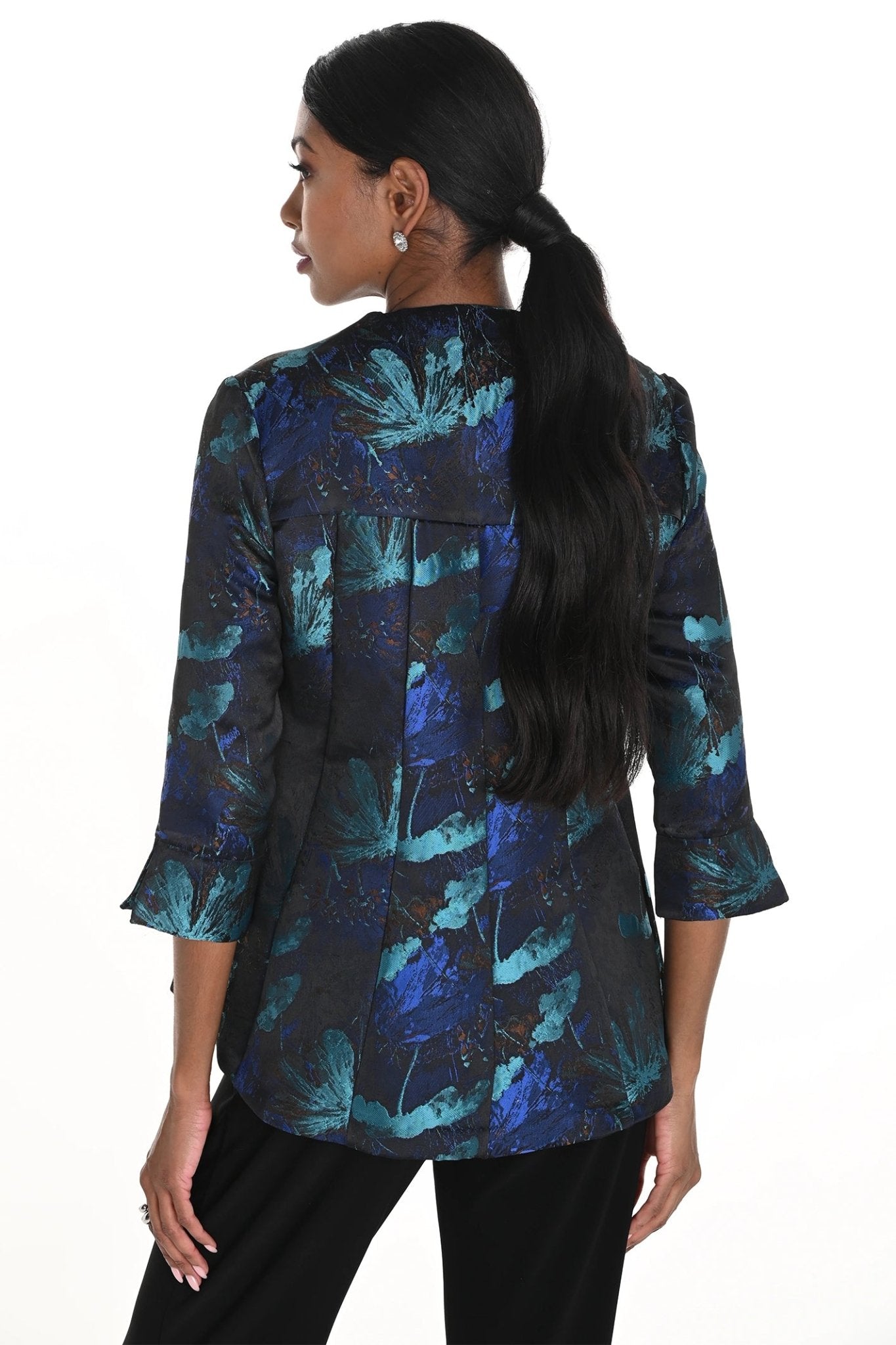 Woman wearing a blue and black floral patterned shirt on a white background