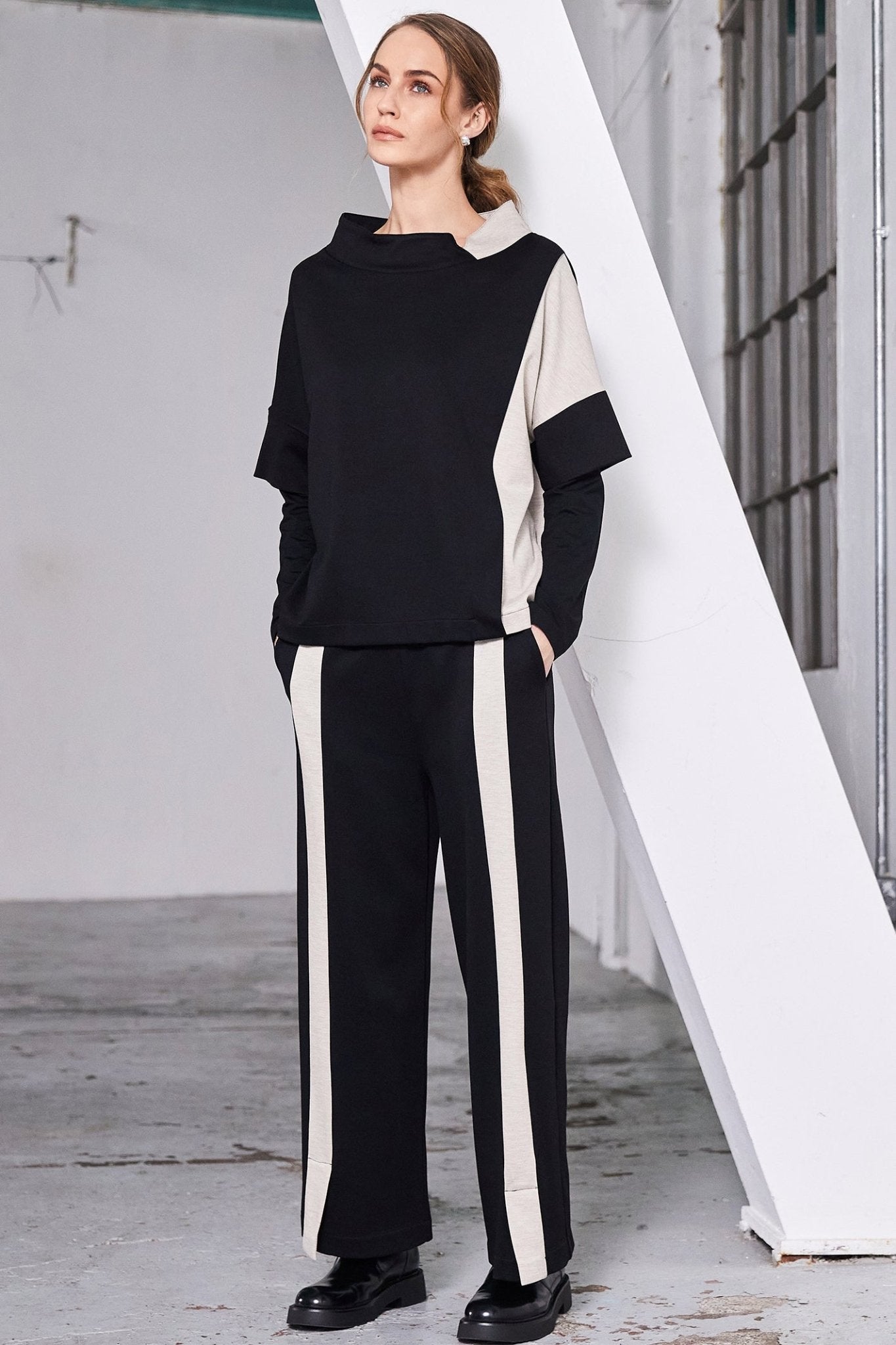 Woman wearing a black and white outfit with a geometric background