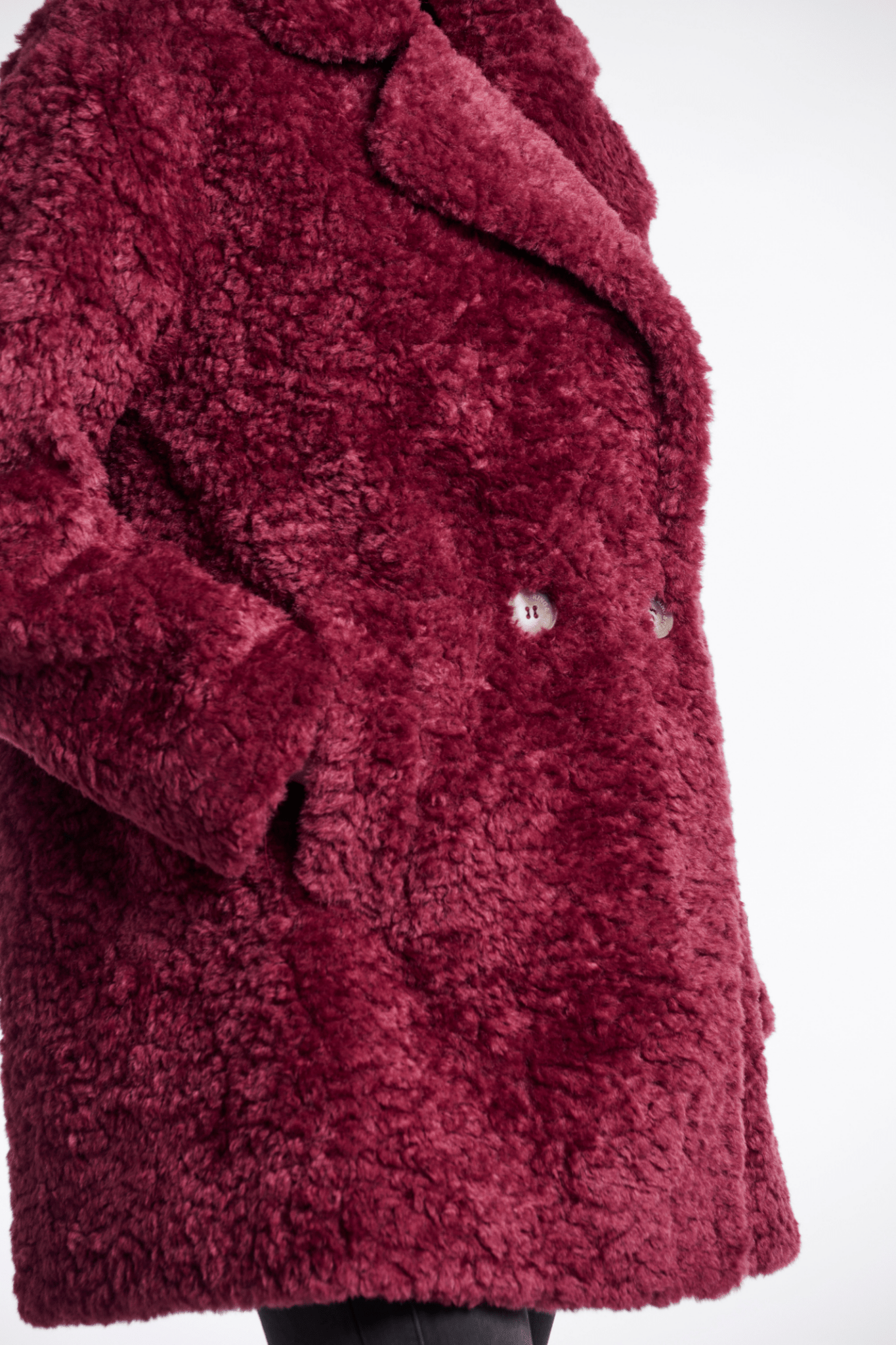 Close-up of a textured red coat with a blurred background