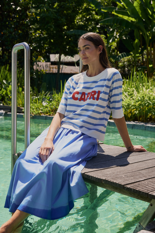 Woman sitting by pool wearing Milano 61-5048-9111 Capri Blue & White Stripe Jumper with Red Print (1604) Shop MILANO at Dotique.