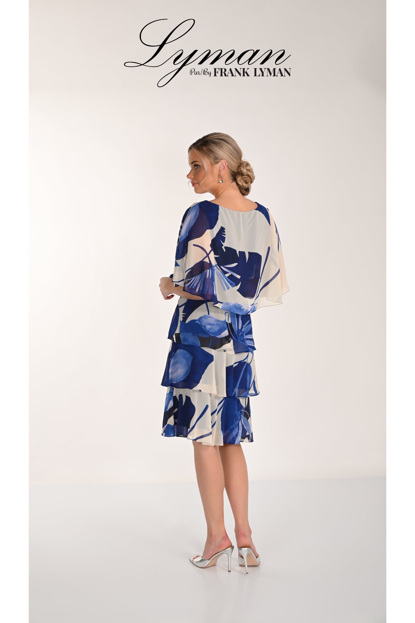 Woman wearing Frank Lyman 268221 Blue Floral Tiered Chiffon Dress by Frank Lyman Shop Frank Lyman at Dotique