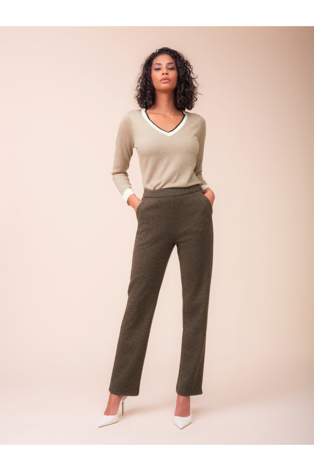 Model wearing the Alison Sheri A48123 Knit Top in a beige tone with contrast trim, styled with trousers, shop Alison Sheri at Dotique.