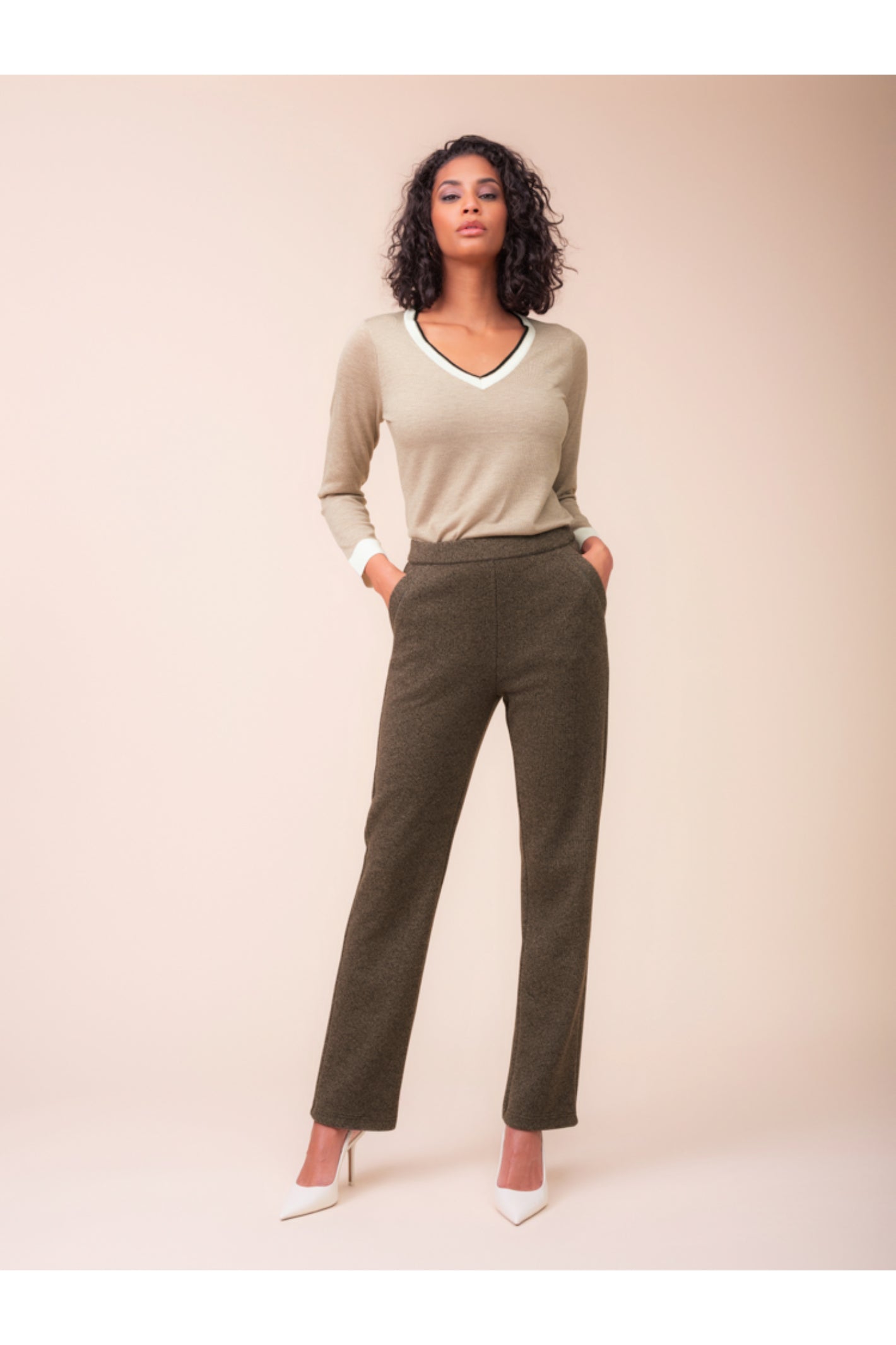 Model wearing the Alison Sheri A48123 Knit Top in a beige tone with contrast trim, styled with trousers, shop Alison Sheri at Dotique.