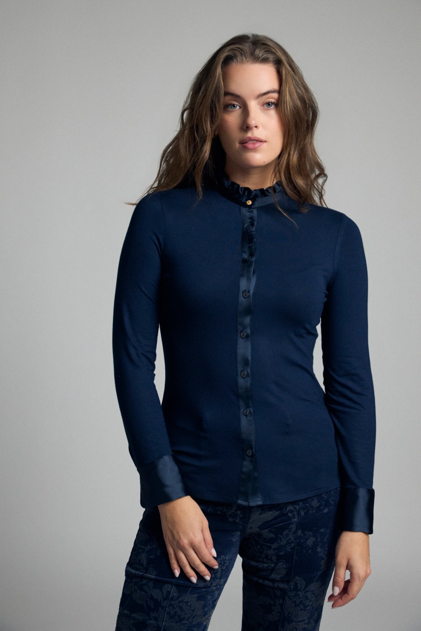Shop the Bariloche 4007115 Andria Women's Shirt in Navy at Dotique. A fitted jersey shirt with a feminine frill neckline, satin trim and elegant styling for work and special occasions.