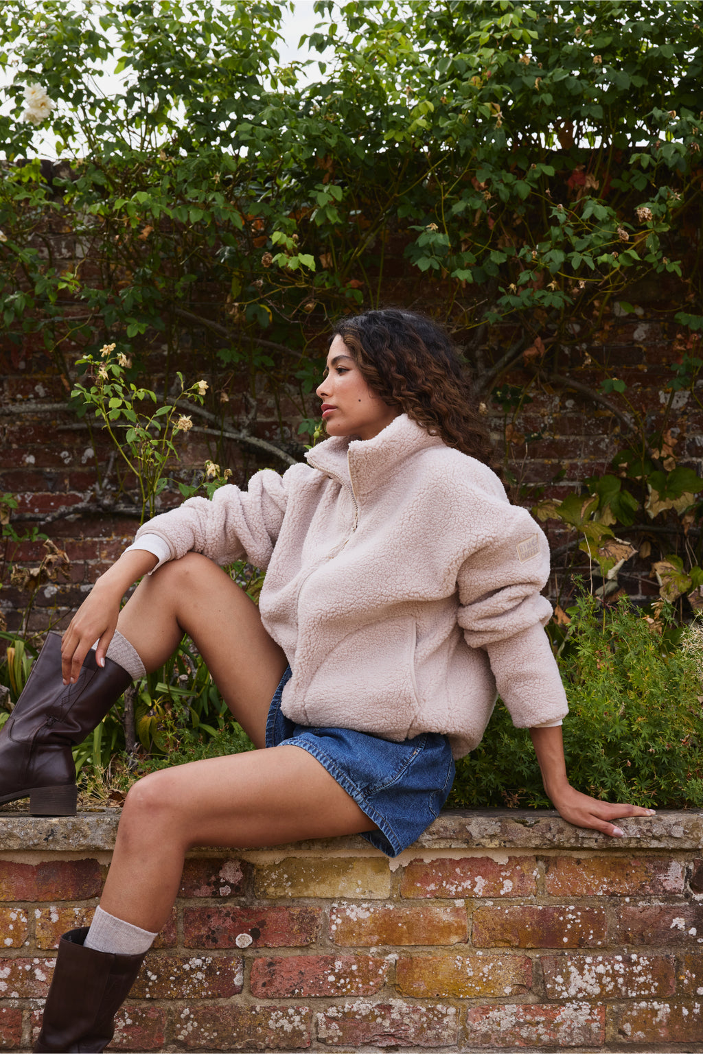 Woman sitting outdoors wearing Gym+Coffee Industry Fleece High Collar Jacket Natural Shop Gym+Coffee at Dotique
