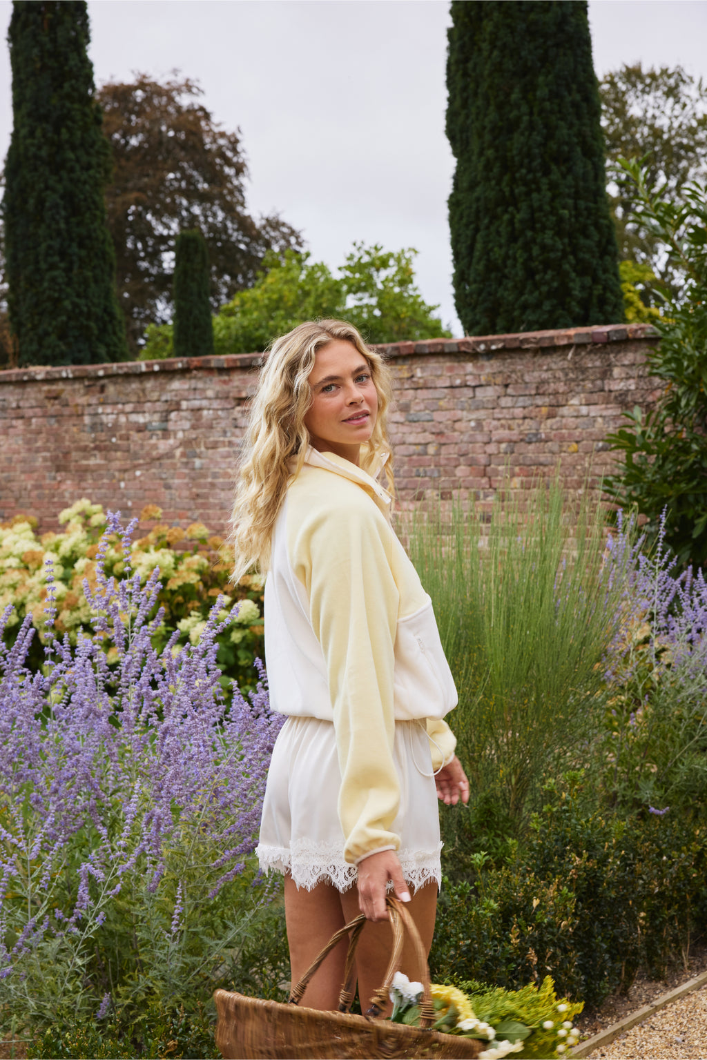 Model wearing Gym+Coffee Snap Polar Fleece Pale Vanilla in garden Shop Gym+Coffee at Dotique