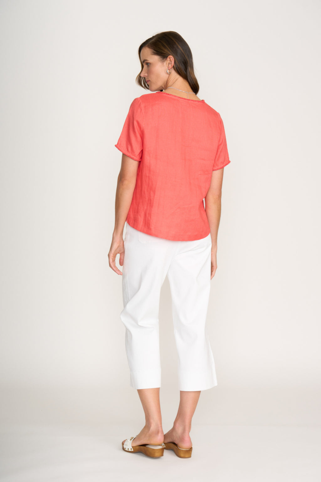 Woman wearing Foil Fo8315 V Benefits Top Melon with white pants standing, shop Foil at Dotique online store.