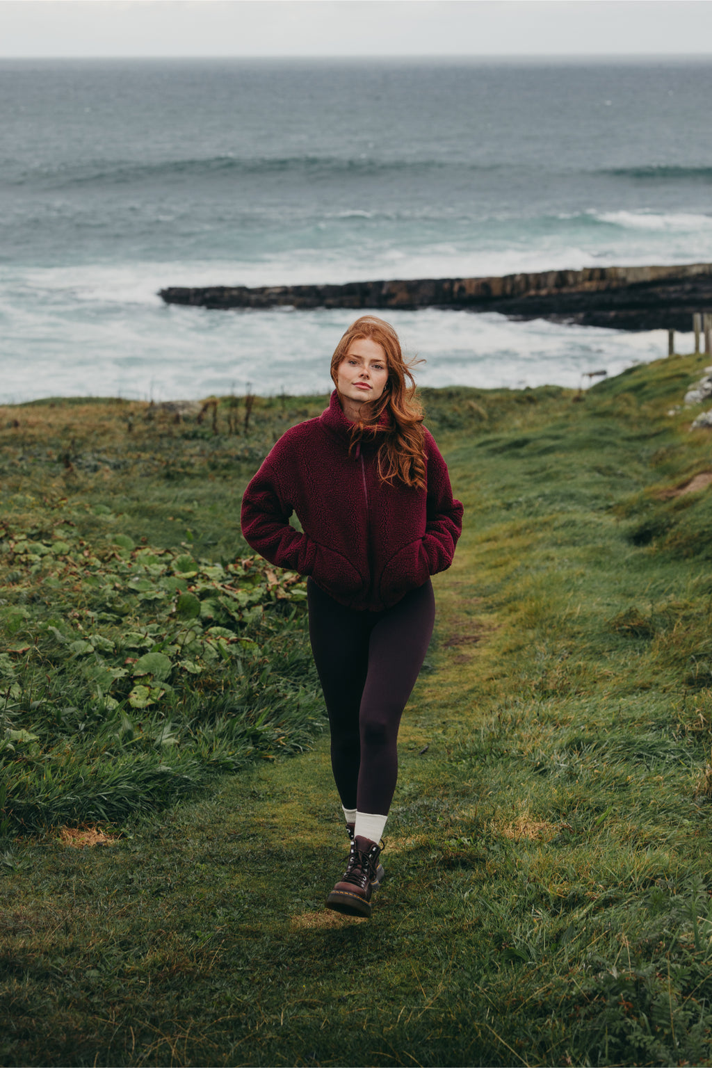 Gym+Coffee Industry Fleece High Collar Jacket Cherry Crush worn by woman on coast You can Shop Gym+Coffee at Dotique