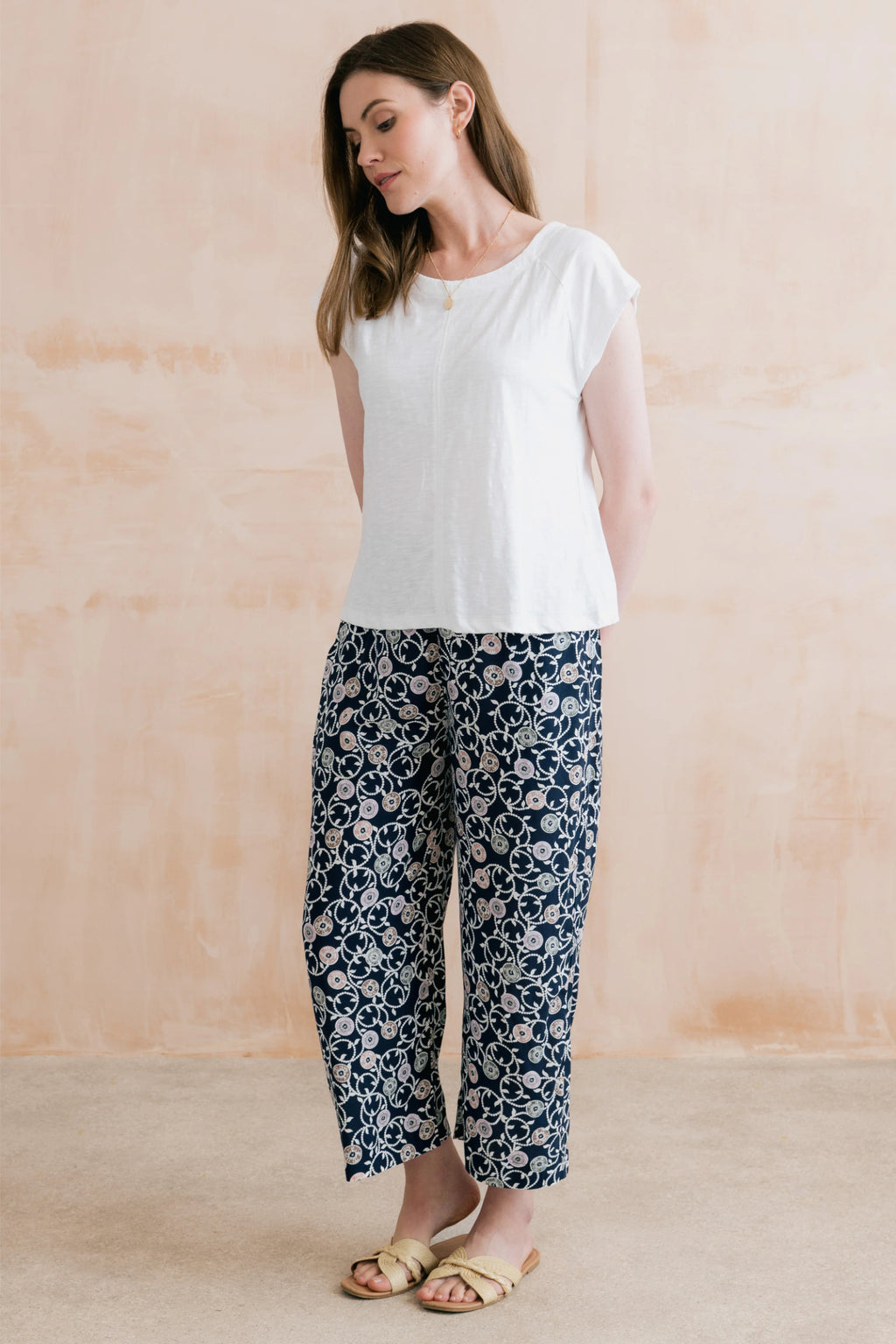 Woman wearing Lily & Me LM26023 Greta Trousers Sea Holly Navy with floral design paired with a white top by Lily & me. Shop Lily & me at Dotique.