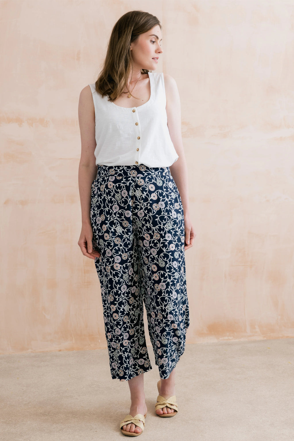 Woman wearing Lily & Me LM26023 Greta Trousers Sea Holly Navy with a floral design paired with a white sleeveless top by Lily & me. Shop Lily & me at Dotique.