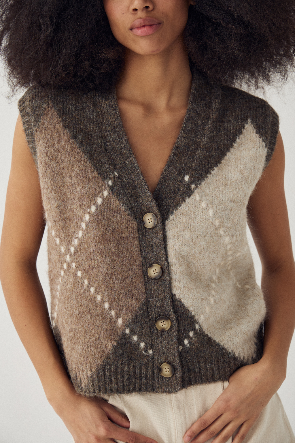 The Noella N-Laiana Knit Vest in Ash Brown Mix. Combining warm mocha, oatmeal, taupe and soft cream tones in a statement argyle design. Shop at Dotique.