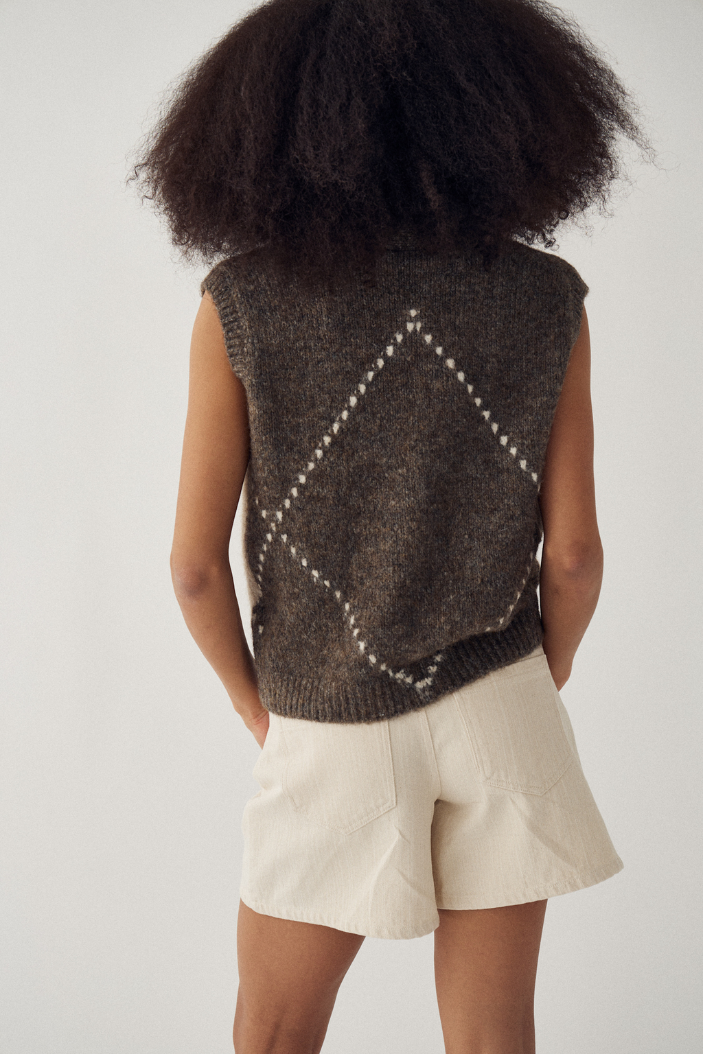 The Noella N-Laiana Knit Vest in Ash Brown Mix. Combining warm mocha, oatmeal, taupe and soft cream tones in a statement argyle design. Shop at Dotique.