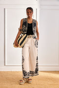 Woman wearing NKN Nekane Adanna White Geometric Print Trousers by nkn nekane, shop nkn nekane at Dotique