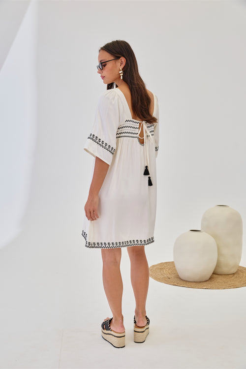 Rear view of model in NKN Nekane Jelani White Short Viscose Dress with 3/4 Sleeves and Bicolour Embroidery by nkn nekane shop Dotique