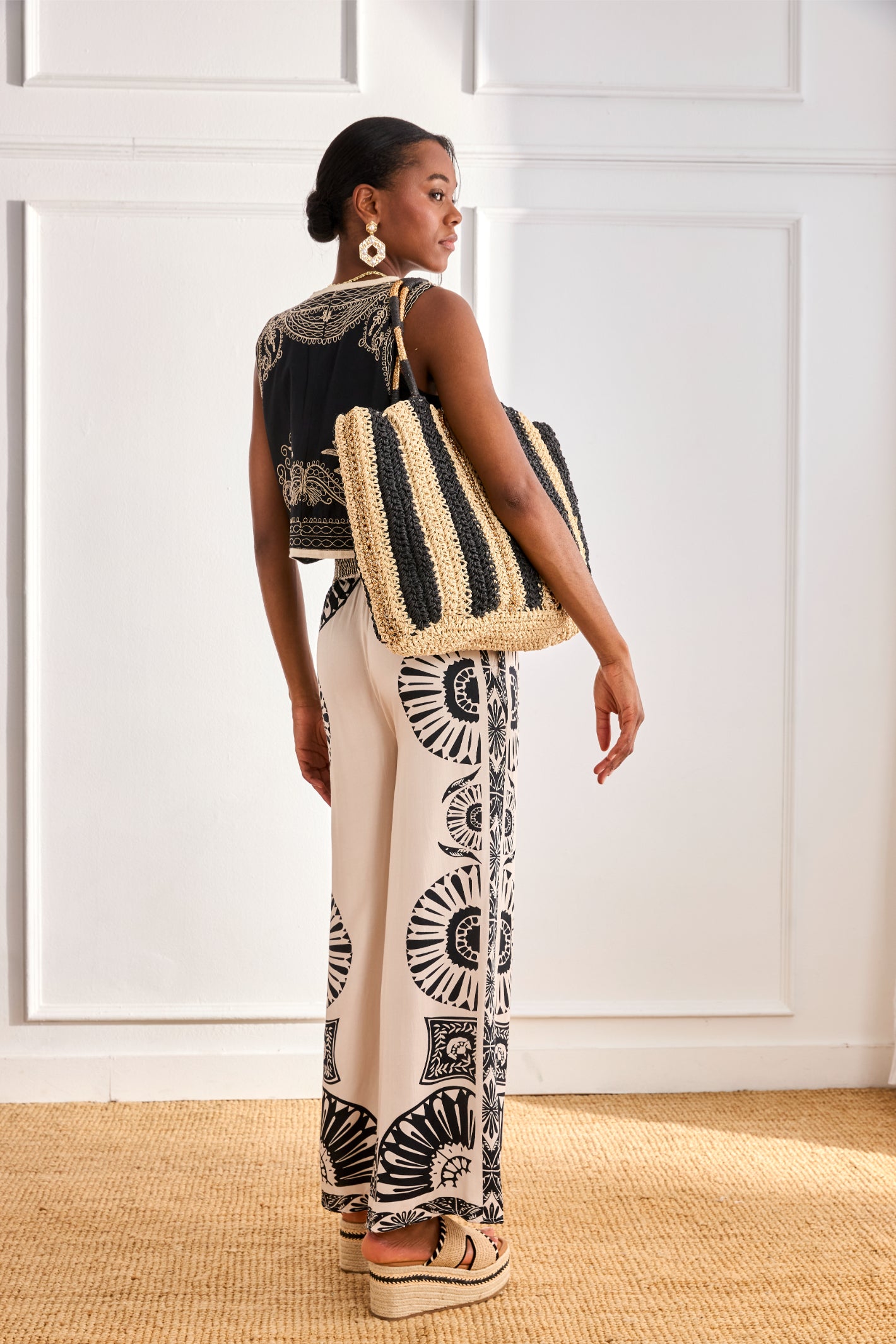 Rear view of model wearing NKN Nekane Adanna White Geometric Print Trousers by nkn nekane, shop nkn nekane at Dotique