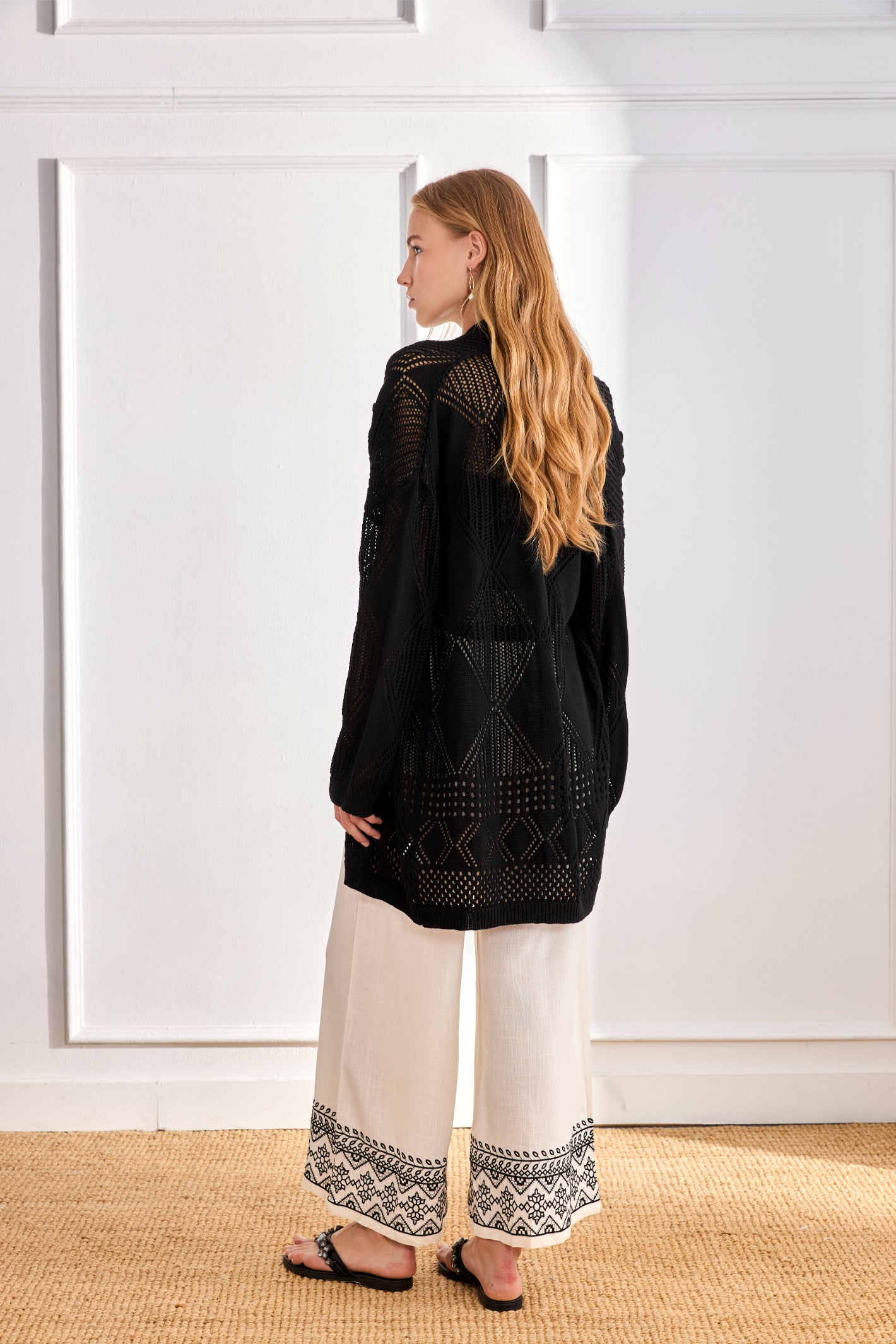 Rear view of model wearing NKN Nekane Arsi Ivory Linen Trousers with Embroidery on Hem and Pocket by nkn nekane, shop at Dotique