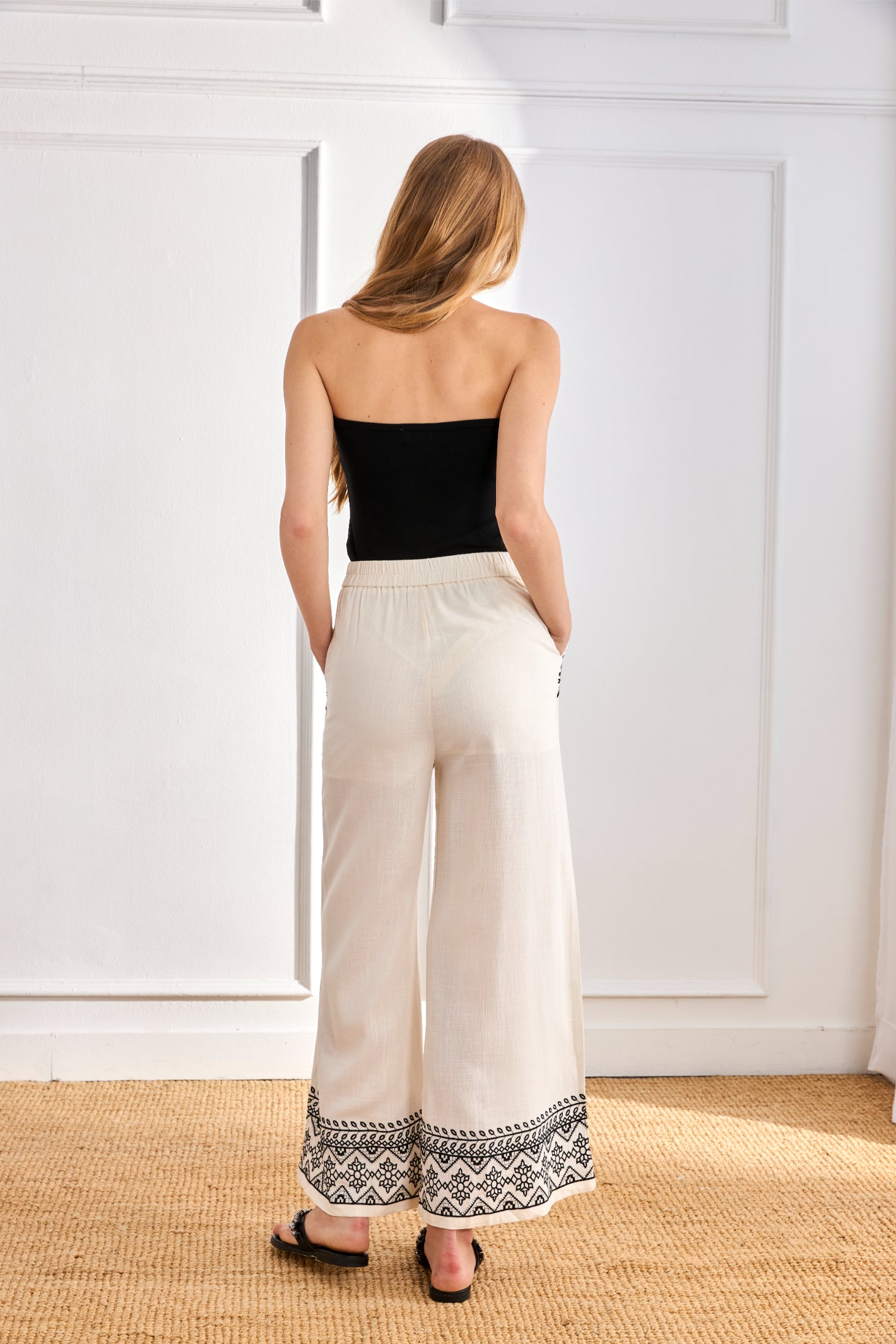 Back view of model wearing NKN Nekane Arsi Ivory Linen Trousers with Embroidery on Hem and Pocket by nkn nekane, shop at Dotique