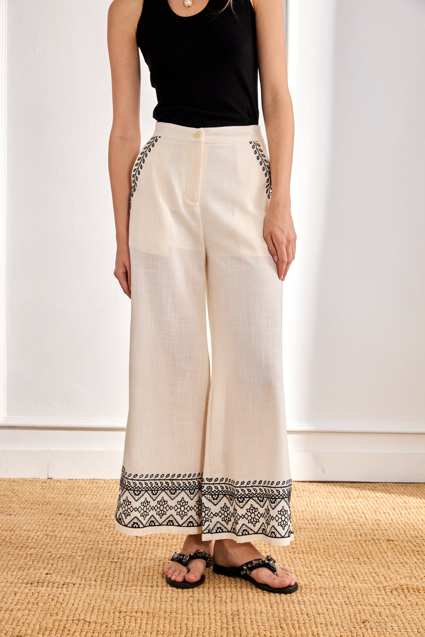 Front view of model wearing NKN Nekane Arsi Ivory Linen Trousers with Embroidery on Hem and Pocket by nkn nekane, shop at Dotique