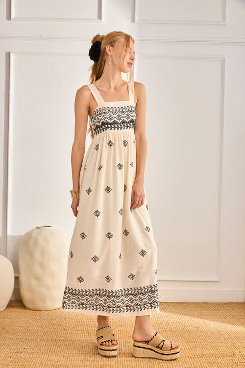 Full-length side view of model in NKN Nekane Urani Ivory Long Linen Dress with Embroidery and Square Neckline, shop nkn nekane at Dotique