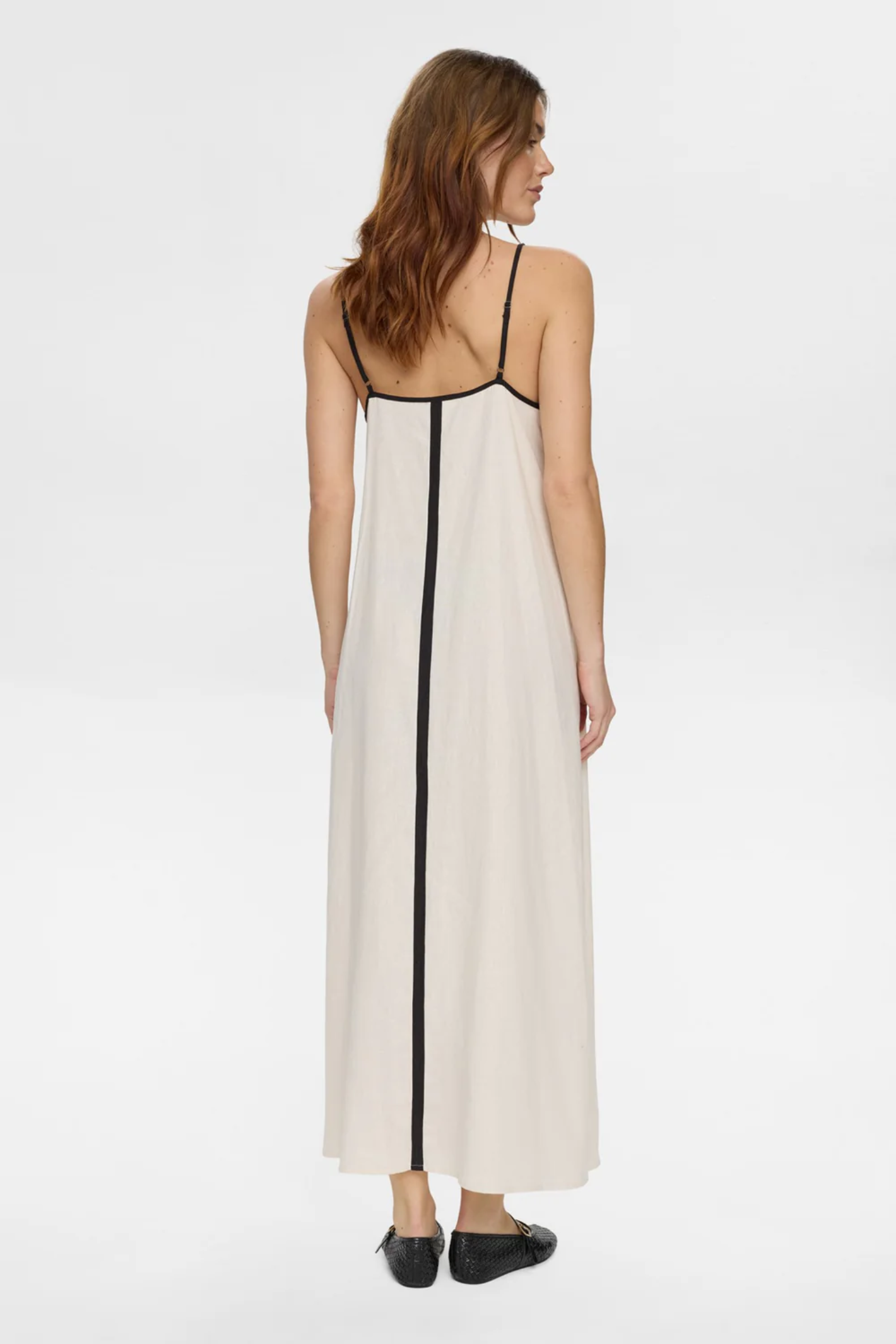 Back view of a woman wearing Numph 706765 Nualani Dress Whitecap Gray with thin black straps and vertical black trim by Numph. Shop Numph at Dotique.