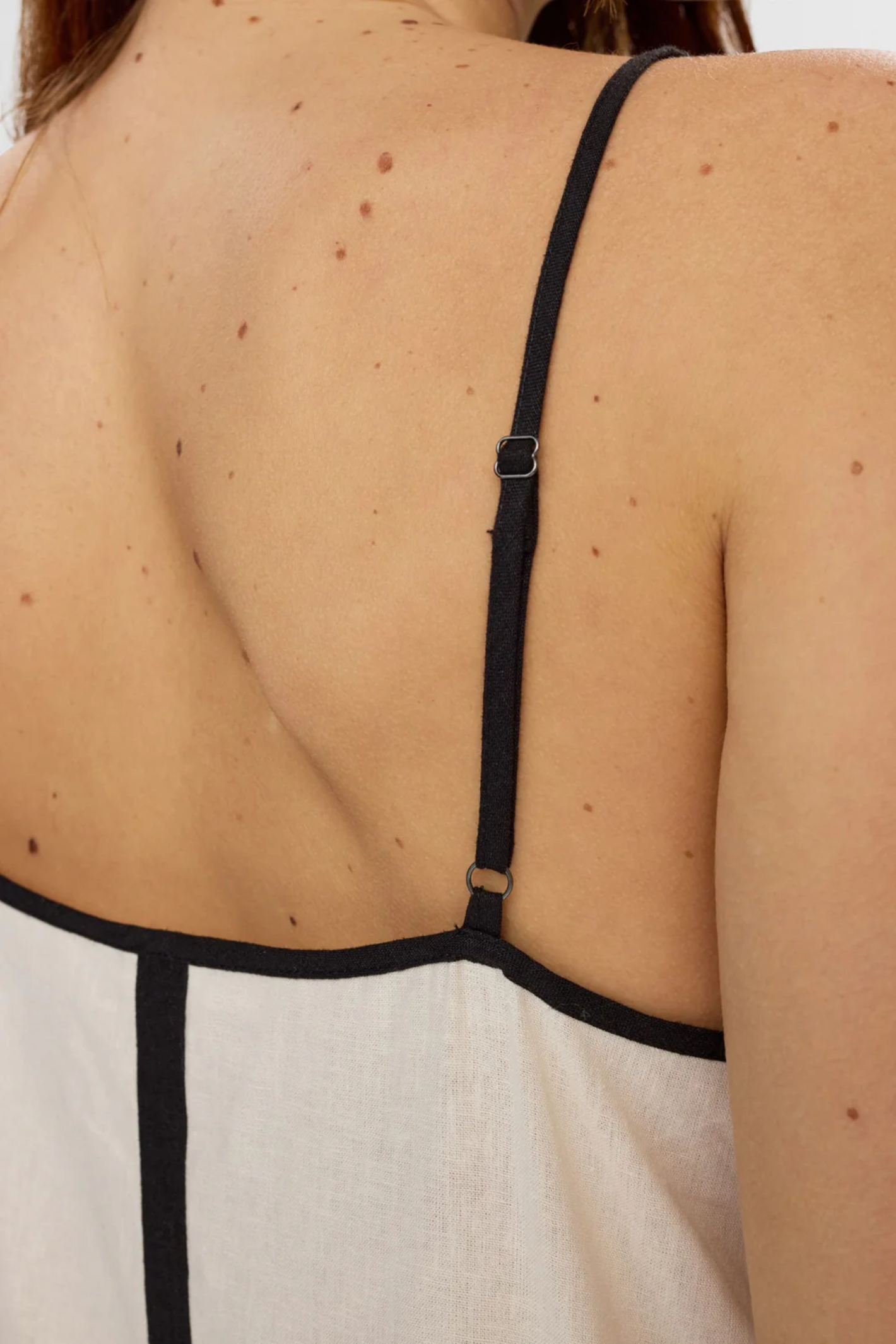Close-up of the back detailing and adjustable black strap on the Numph 706765 Nualani Dress Whitecap Gray by Numph. Shop Numph at Dotique.