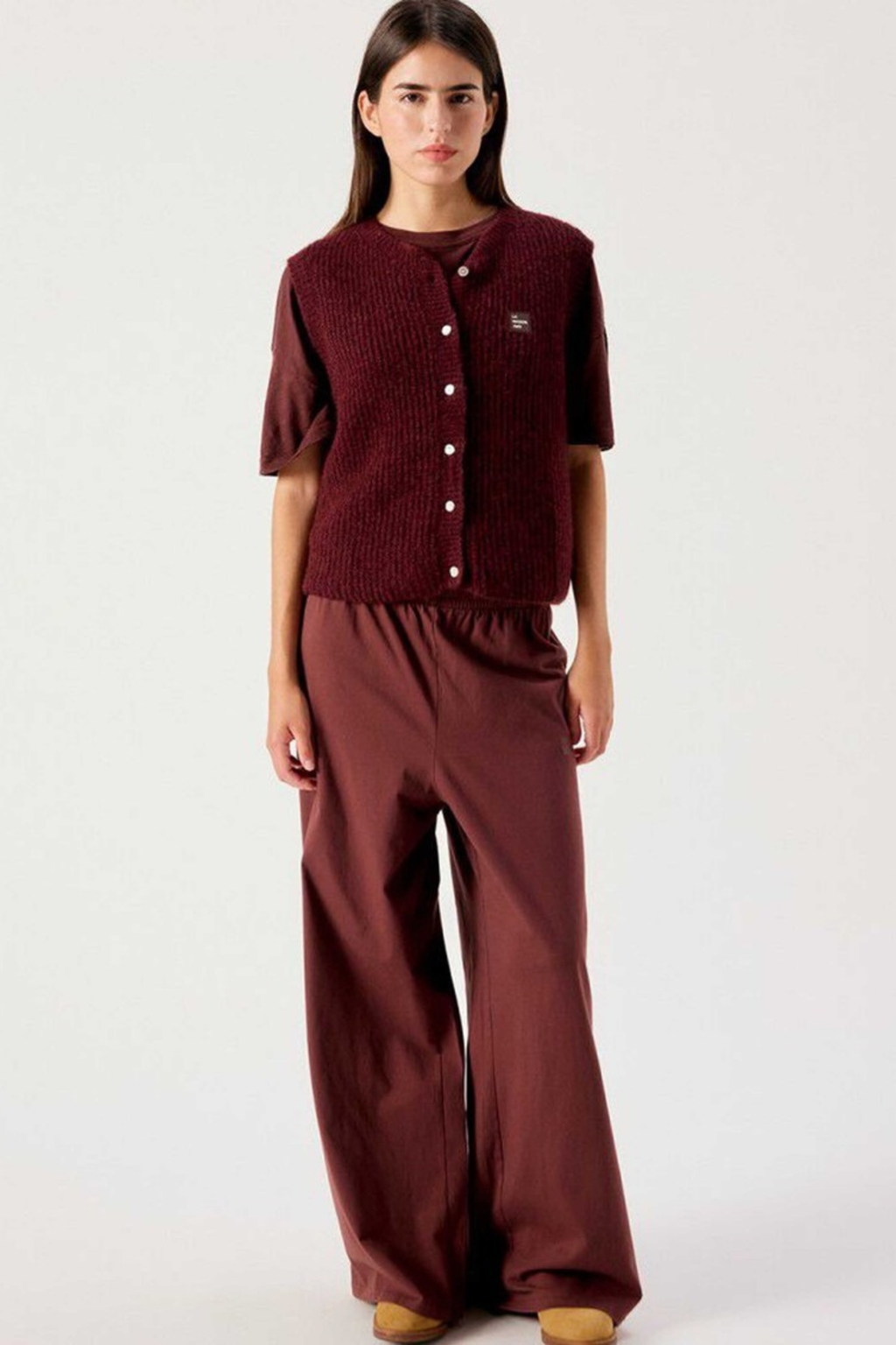 Shop the American Vintage East Knitted Waistcoat in Acerola Chine at Dotique. A soft alpaca blend knitted waistcoat with a relaxed fit, button front and rich burgundy melange colour.