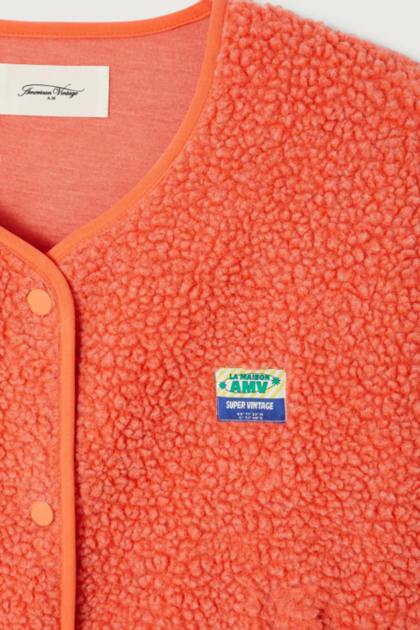 Shop the American Vintage Hoktown Sleeveless Fleece Gilet in Sunset Chine at Dotique. A cosy recycled fleece layering piece in a vibrant coral orange with a relaxed fit.