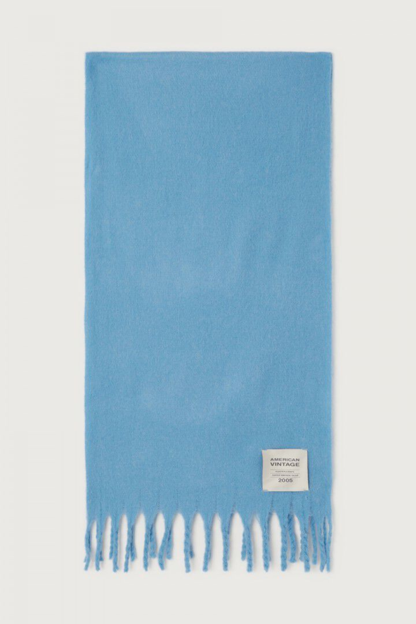 Shop the American Vintage Zinaco Scarf in Siberie at Dotique. A soft brushed scarf with fringed edges in a vibrant blue shade for effortless everyday styling.