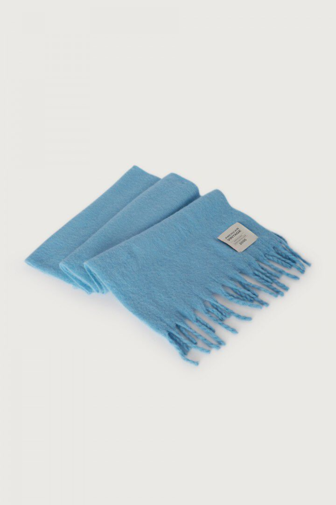 Shop the American Vintage Zinaco Scarf in Siberie at Dotique. A soft brushed scarf with fringed edges in a vibrant blue shade for effortless everyday styling.