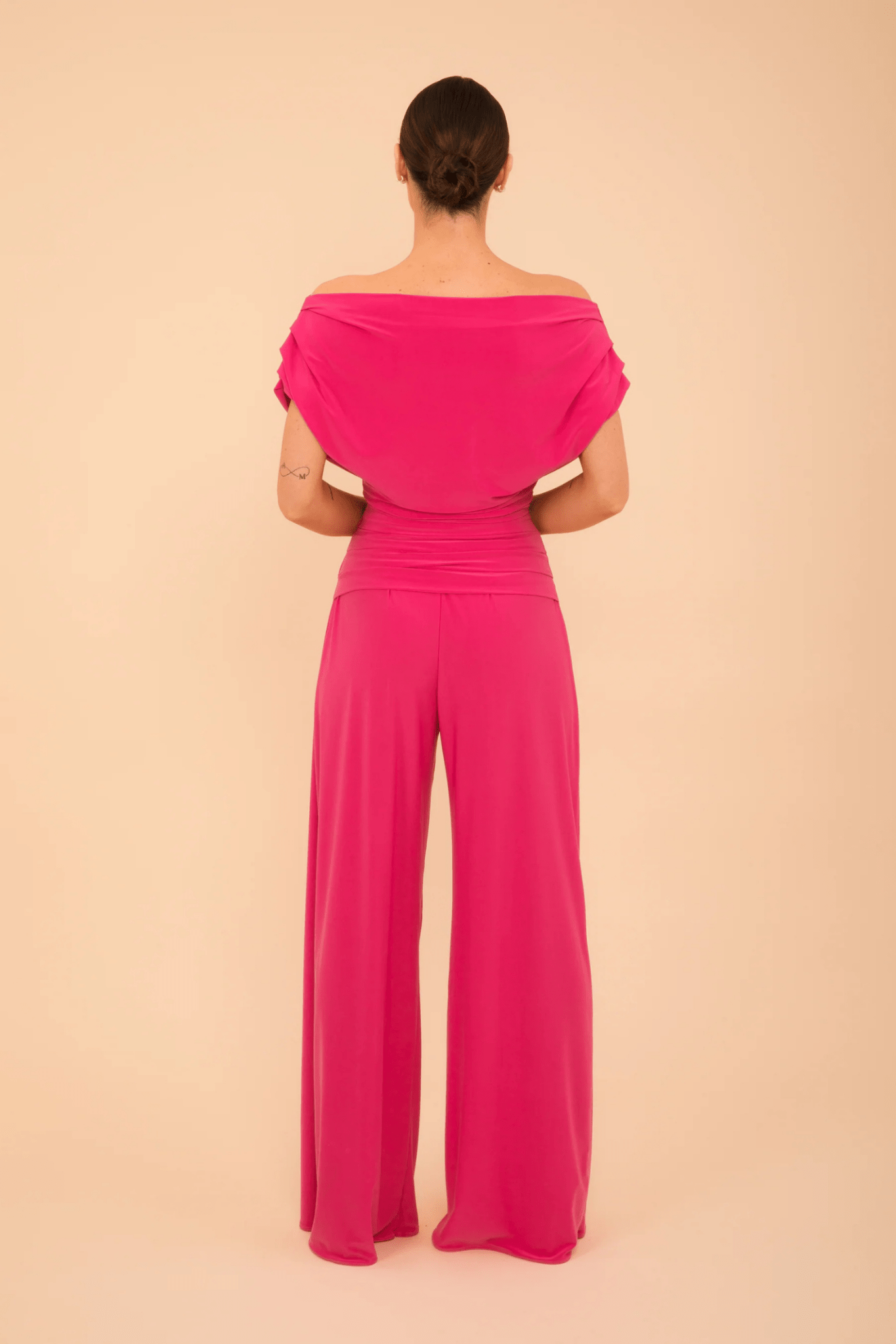 Back view of model wearing ATOM LABEL Carbon Jumpsuit in Hot Pink by ATOM LABEL, shop ATOM LABEL at Dotique.