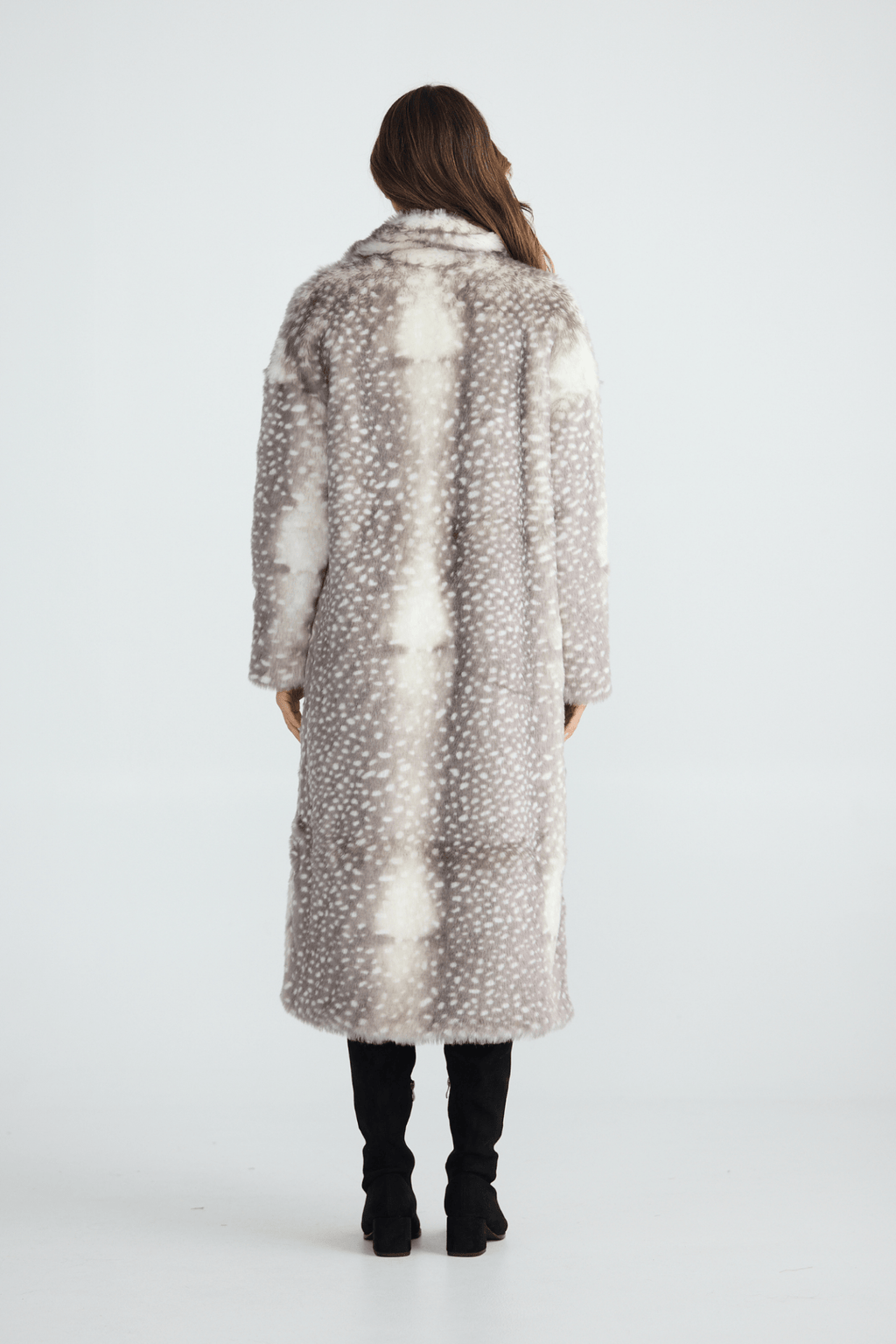 Person wearing a long, patterned coat on a white background