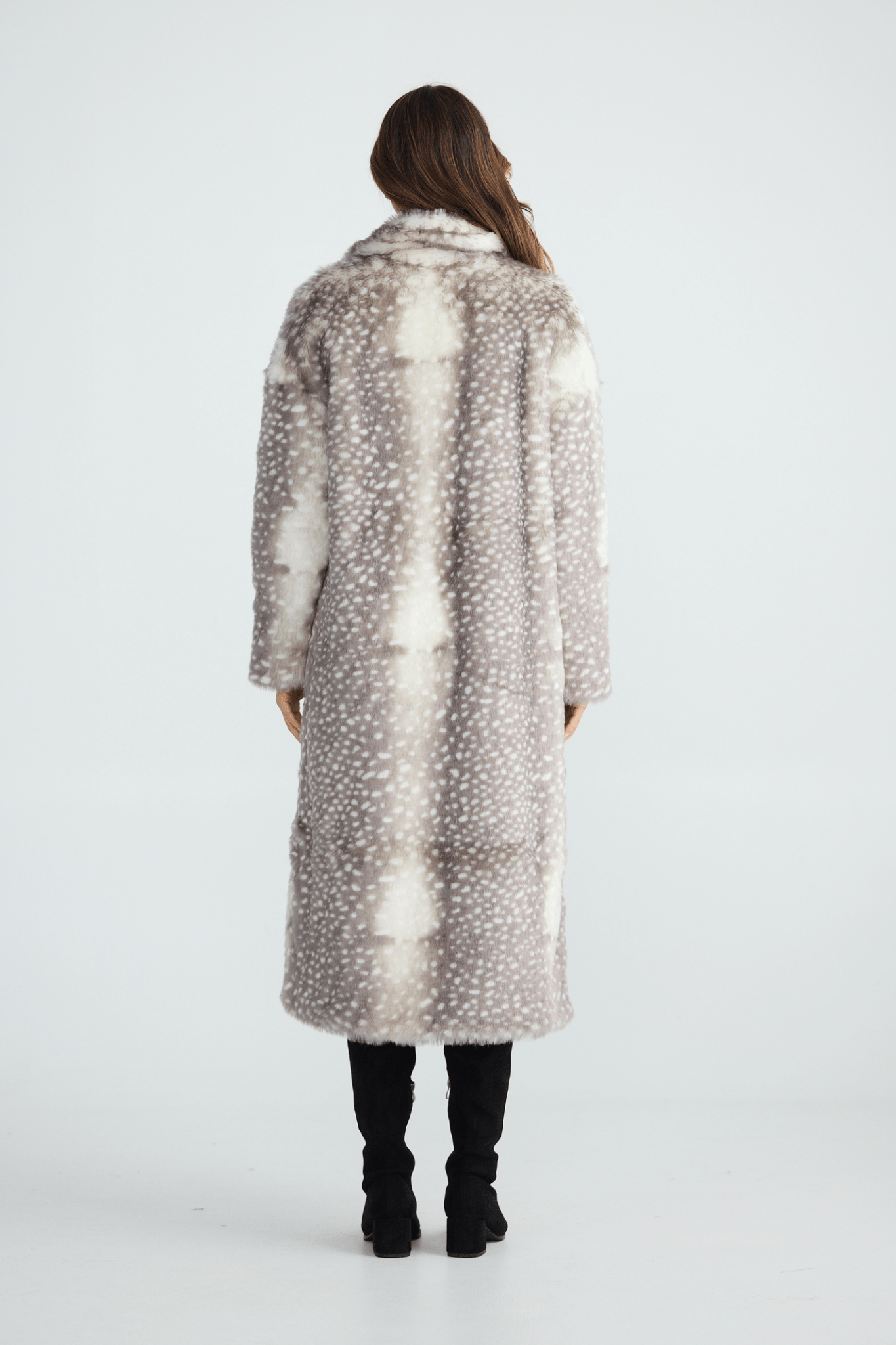 Person wearing a long, patterned coat on a white background