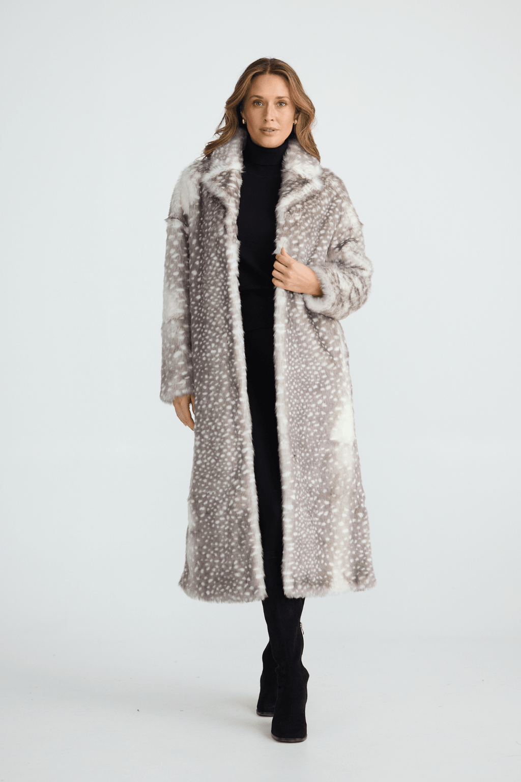 Woman wearing a long fur coat on a white background