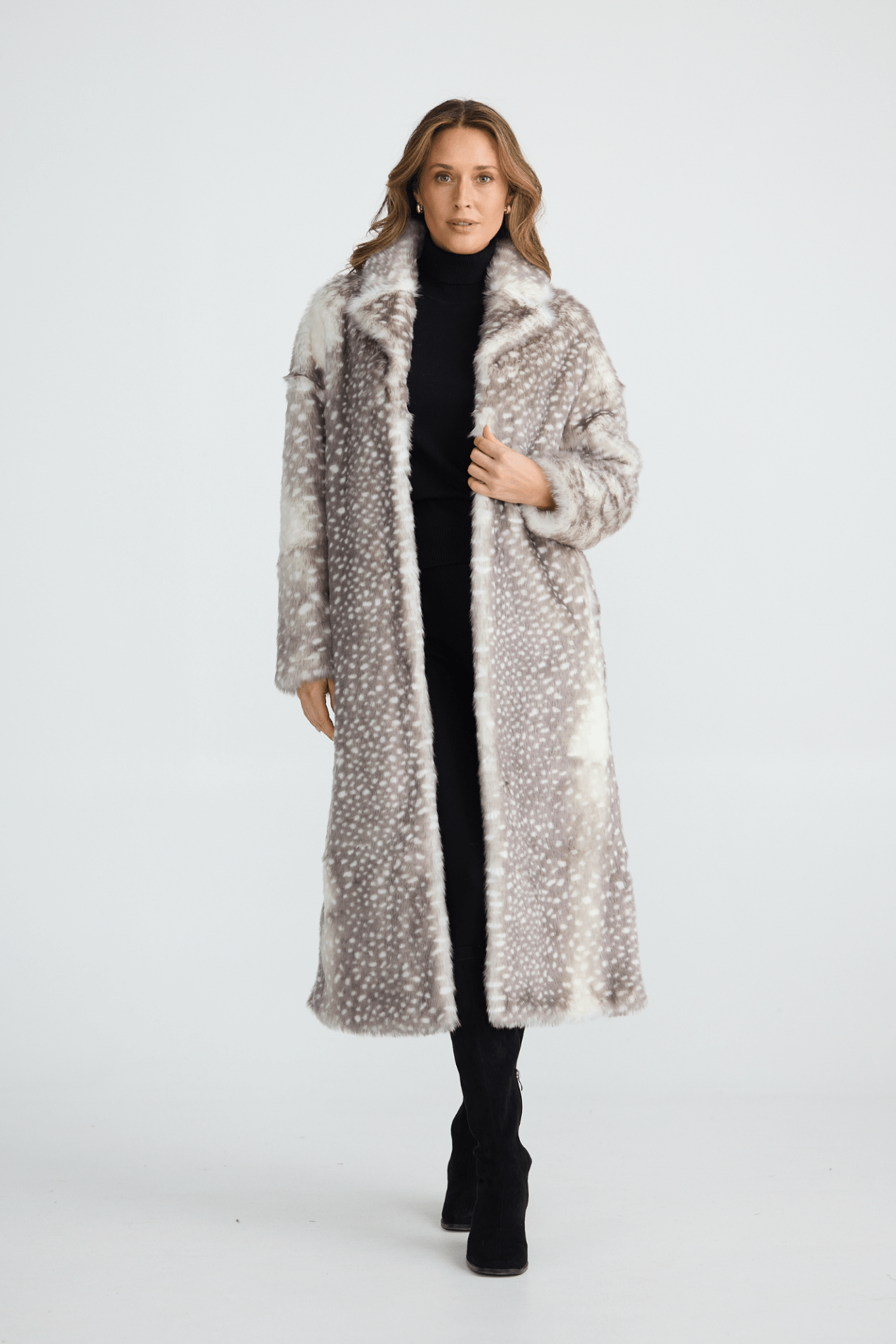 Woman wearing a long fur coat on a white background