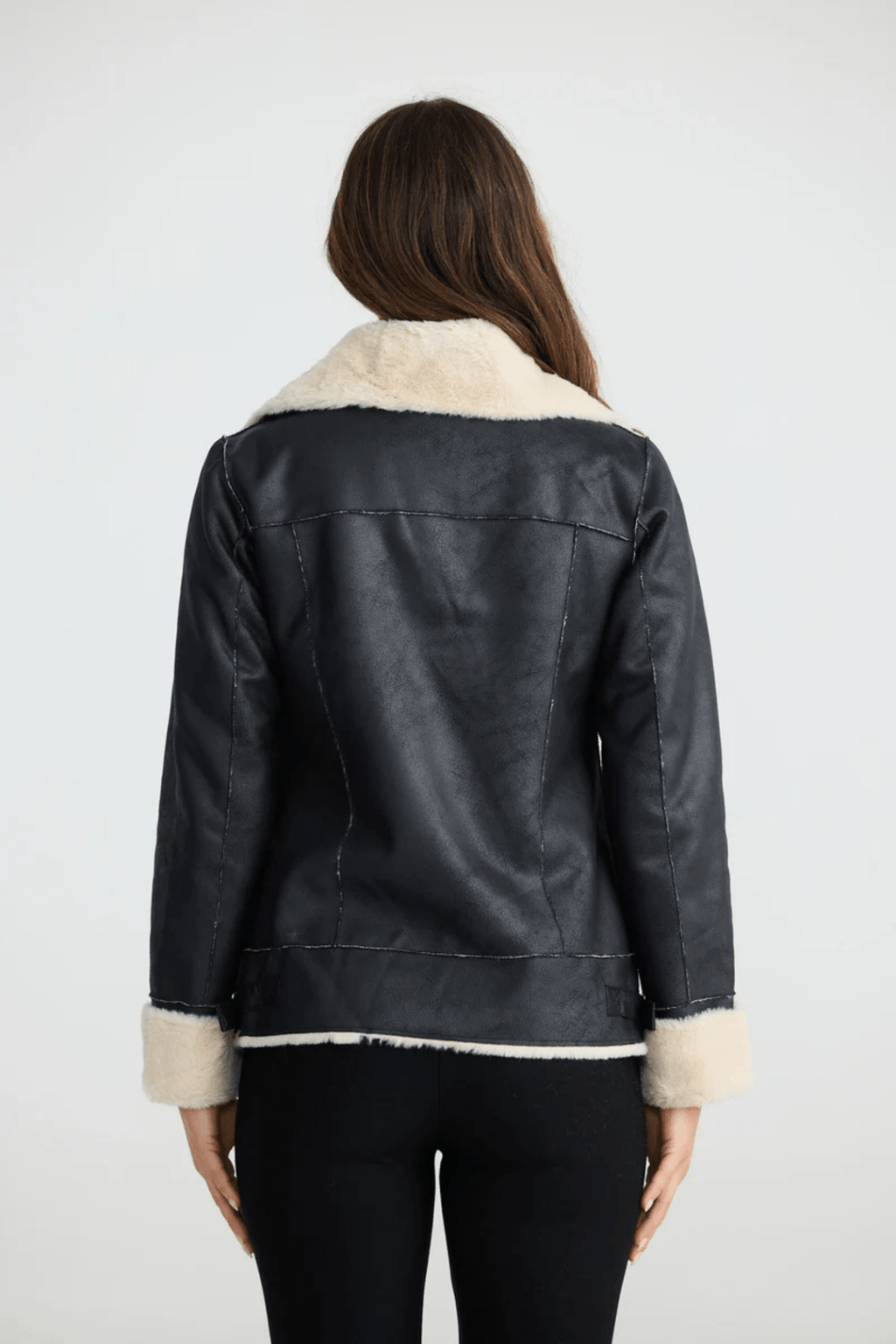 Woman wearing a black coat with white fur trim on a white background. Brave + True BT25161 Haywood Jacket – Black. Shop now at Dotique