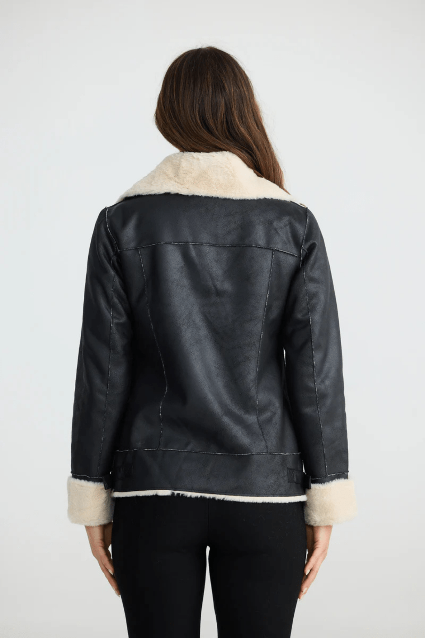 Woman wearing a black coat with white fur trim on a white background. Brave + True BT25161 Haywood Jacket – Black. Shop now at Dotique
