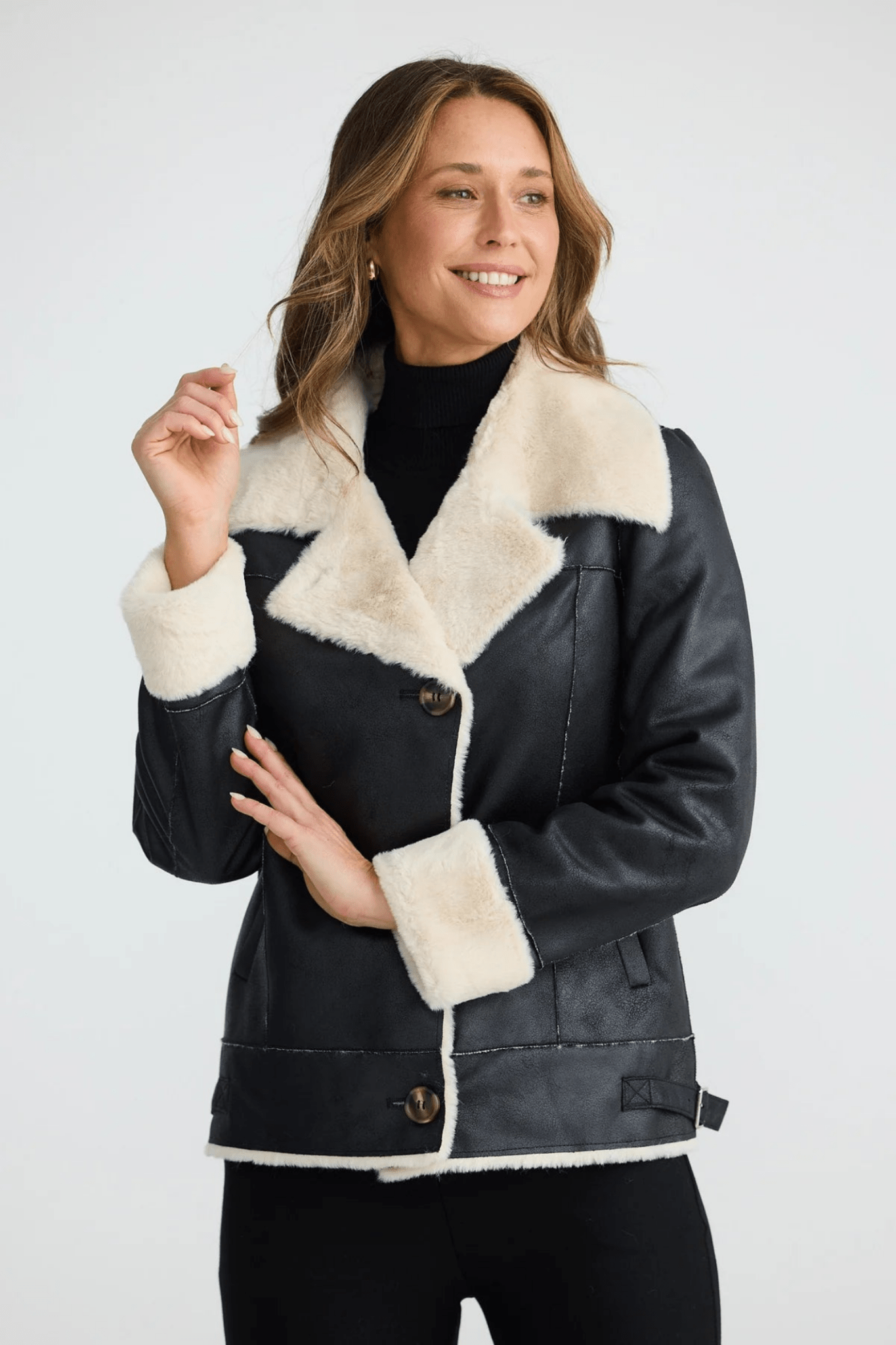Woman wearing a black coat with white fur trim on a white background. Brave + True BT25161 Haywood Jacket – Black. Shop now at Dotique