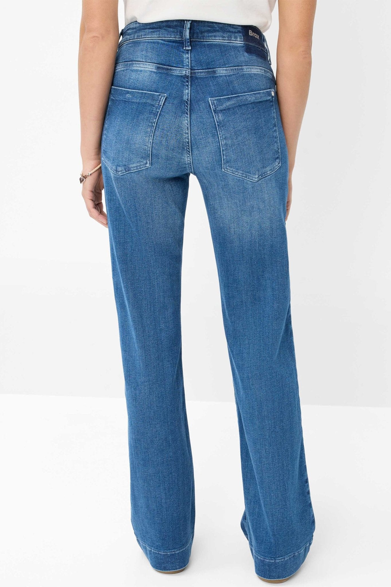 Blue jeans worn by a person on a white background