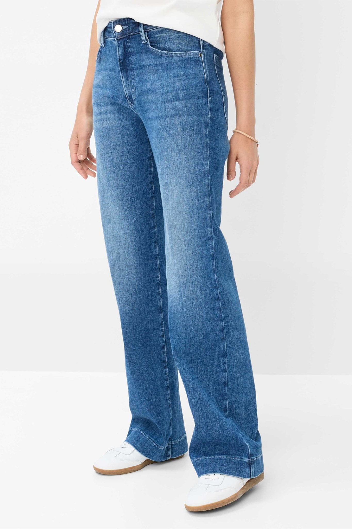 Person wearing blue jeans on a white background