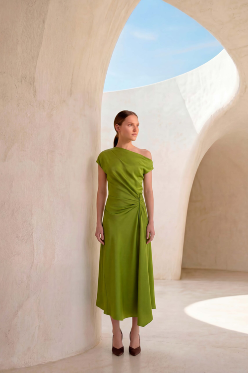 Model wearing the Carla Ruiz 53035 Midi Dress Lima in vibrant green with an asymmetric shoulder design, shop Carla Ruiz at Dotique.