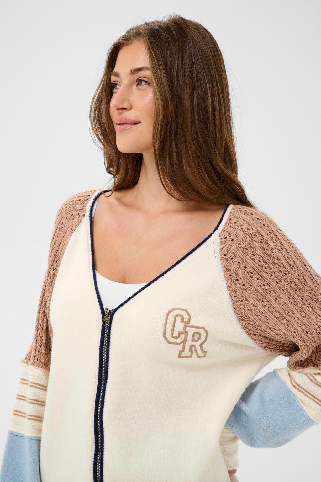 Close-up of model wearing Cream CRPura Knit Jacket Whisper White 10614765 by Cream with textured sleeves, shop the vendor at Dotique