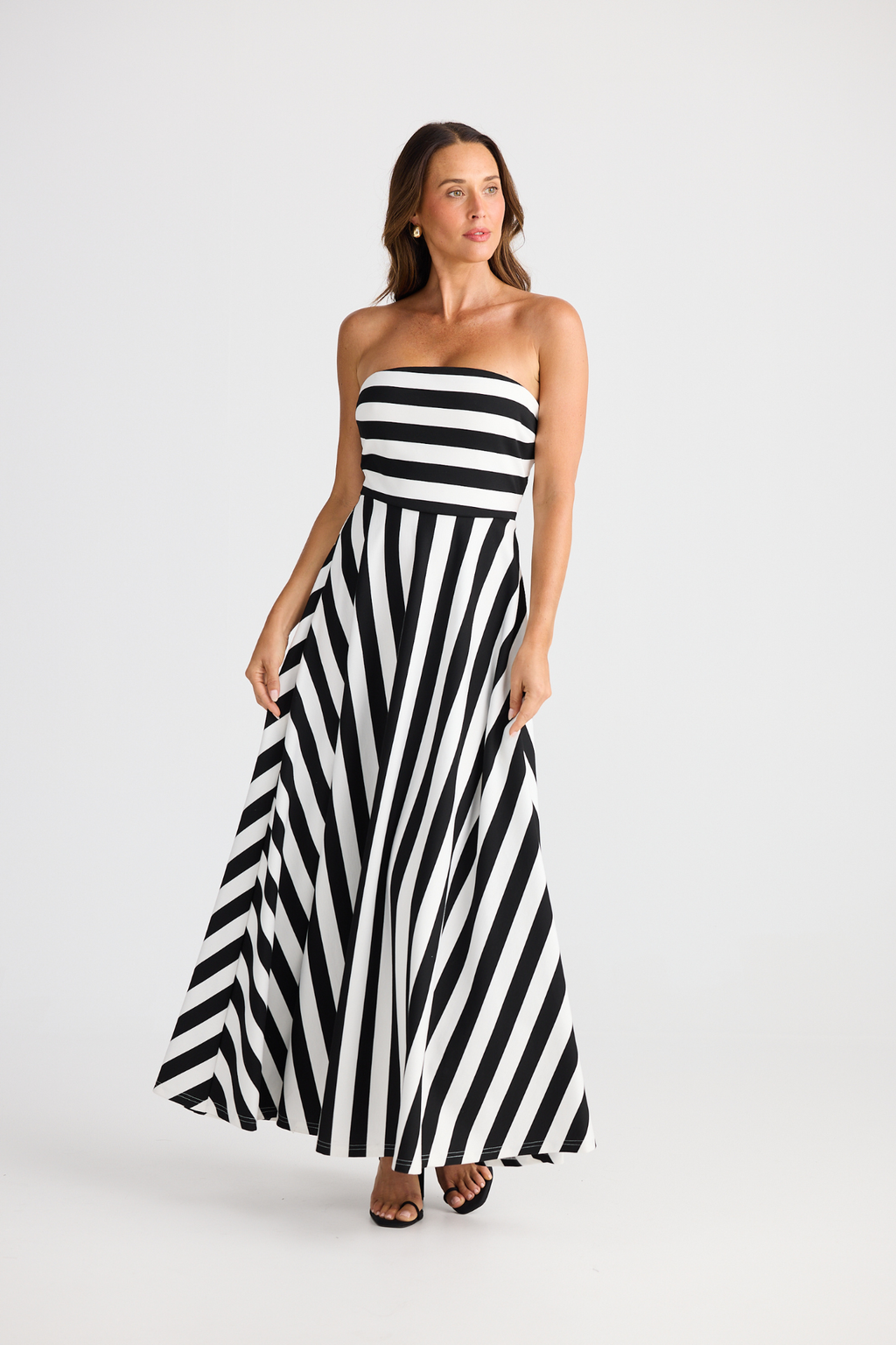 Brave + True Thandie Strapless Dress in black wide stripe. Full-length jersey ponte dress with flared skirt. Shop at Dotique.