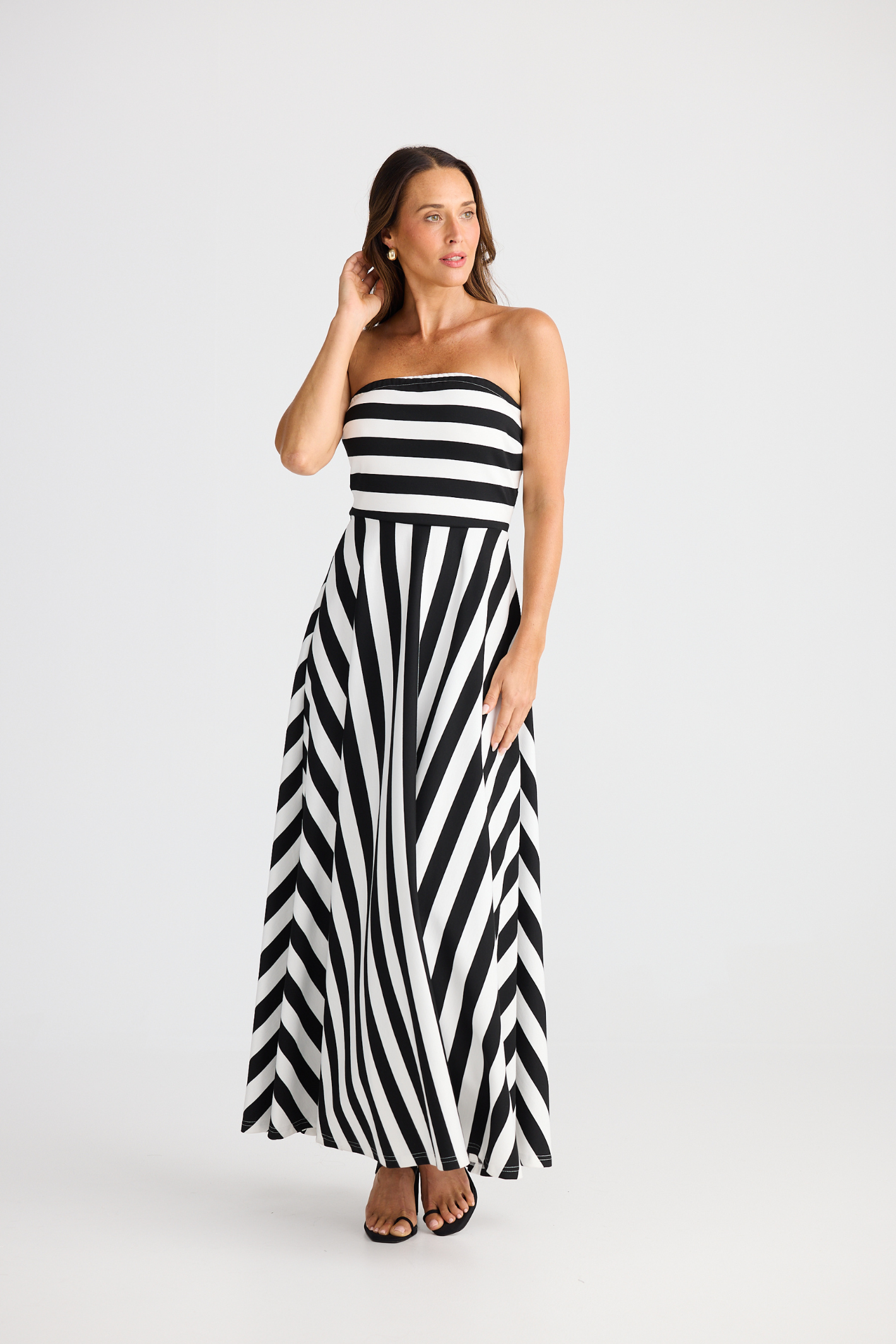 Brave + True Thandie Strapless Dress in black wide stripe. Full-length jersey ponte dress with flared skirt. Shop at Dotique.