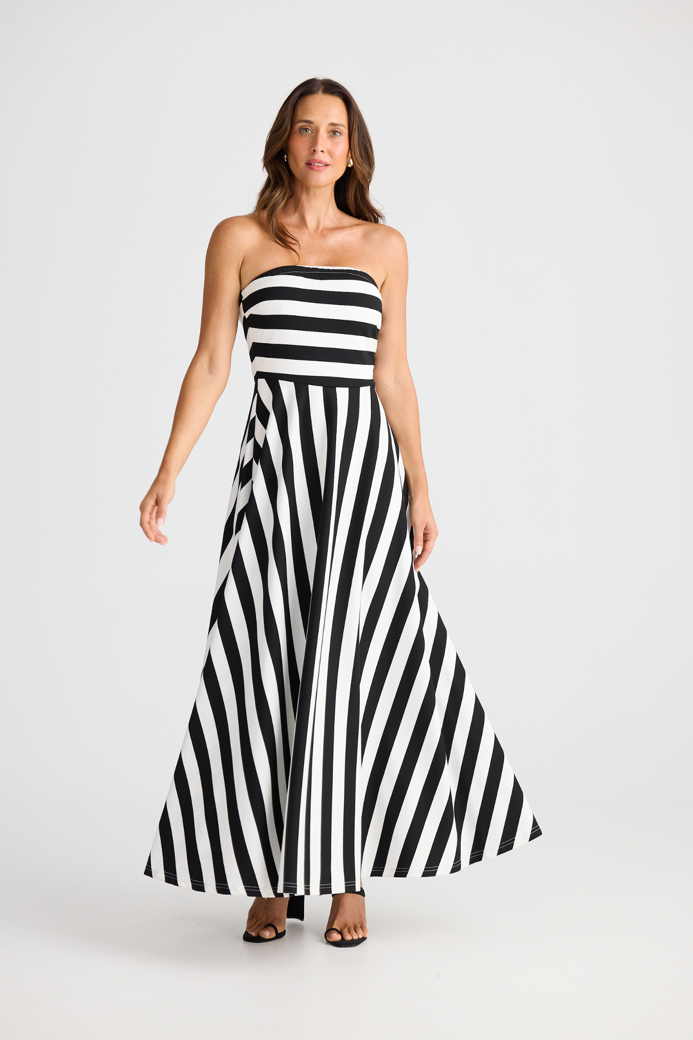 Brave + True Thandie Strapless Dress in black wide stripe. Full-length jersey ponte dress with flared skirt. Shop at Dotique.