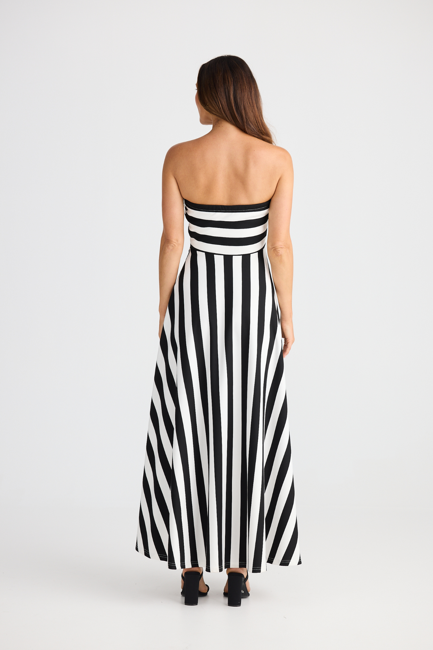Brave + True Thandie Strapless Dress in black wide stripe. Full-length jersey ponte dress with flared skirt. Shop at Dotique.