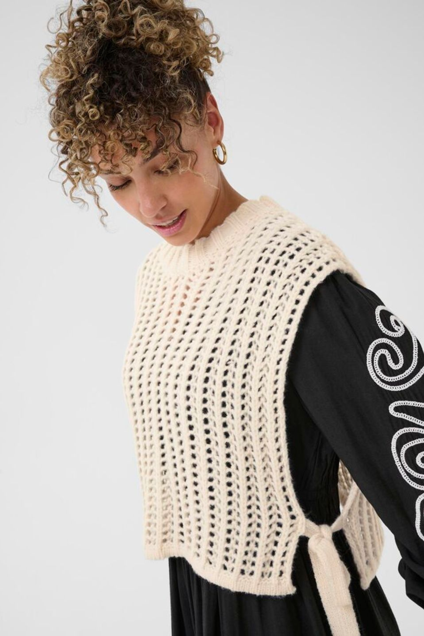 Lightweight open knit slipover in whisper white by Cream. Easy to layer with shirts or dresses for relaxed everyday style. Shop at Dotique.