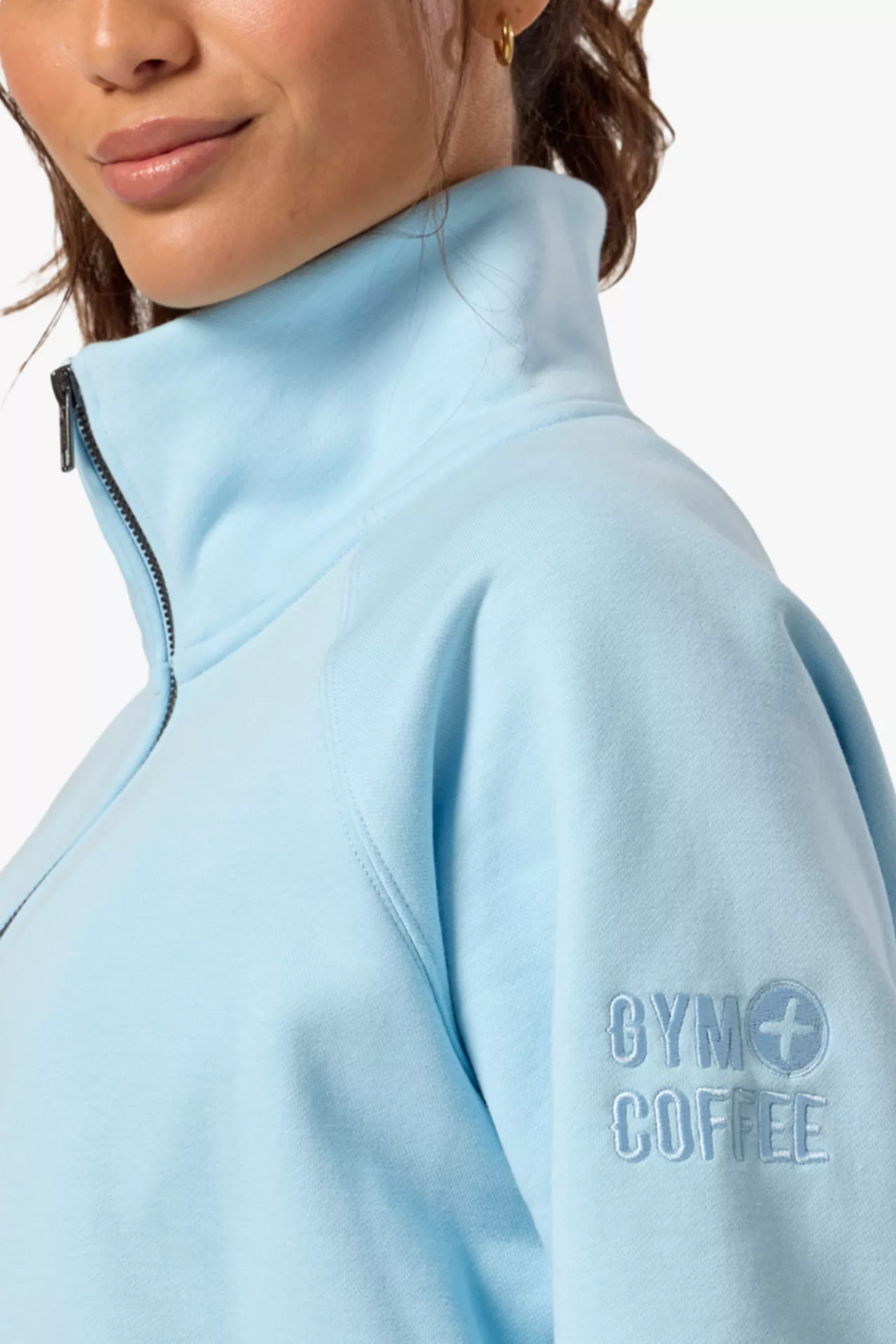 Close-up of a woman wearing Gym+Coffee Clubhouse Quarter Zip in Baby Blue by Gym+Coffee Shop the Gym+Coffee at Dotique