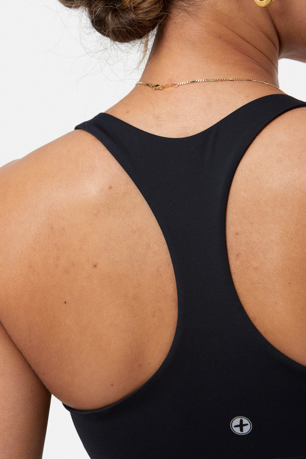 Close-up of a woman wearing Gym+Coffee Relentless Bra Black showing racerback design Shop Gym+Coffee at Dotique